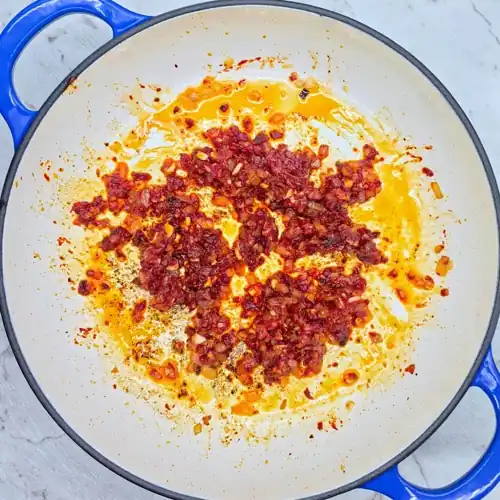  Saute the chopped garlic, tomato paste, chilli flakes and smoked paprika until cooked out and dark in colour. 