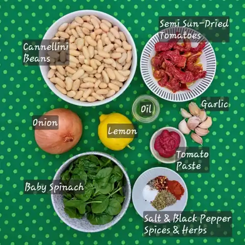  Labelled Ingredients for Marry Me Beans recipe. Oil, onion, garlic, tomato paste, dried herbs, chilli flakes, smoked paprika, cannellini beans, semi-dried tomatoes, lemon juice, baby spinach. 