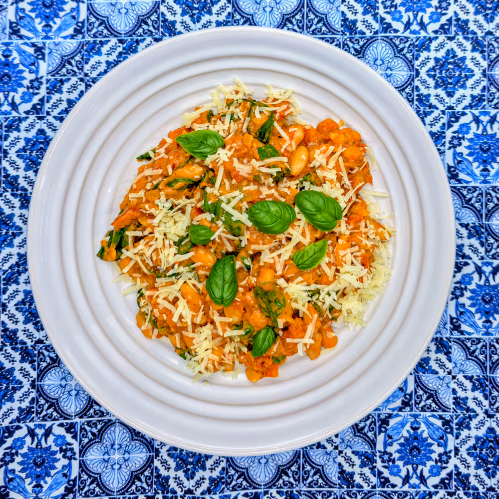  Plated Marry Me Beans garnished with grated parmesan and fresh basil leaves.  